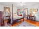 Cozy bedroom featuring a four-poster bed, hardwood floors, and a quaint sitting area at 401 Harmon Park Blvd., Marion, SC 29571