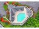 Aerial view of a community pool surrounded by a deck with tables and chairs and colorful landscaping at 4228 Friendfield Trace, Little River, SC 29566
