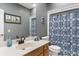 Well-lit bathroom with a white vanity, framed mirror, and shower with a patterned curtain at 4228 Friendfield Trace, Little River, SC 29566