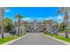 Condo complex with palm trees, manicured landscaping, and a parking lot with multiple cars parked at 4366 Rivergate Ln. # 306, Little River, SC 29566