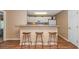 Kitchen features a breakfast bar with wicker stools, white cabinets and neutral color scheme at 4366 Rivergate Ln. # 306, Little River, SC 29566