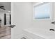 A clean bathroom featuring a soaking tub with black fixtures next to a window at 4486 Bethel Rd., Aynor, SC 29511