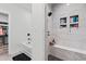 Bright bathroom showcasing a tiled shower, built-in shelving, and a tub with black hardware at 4486 Bethel Rd., Aynor, SC 29511