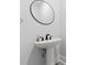 Modern half-bathroom showcasing a round mirror and a stylish pedestal sink at 4486 Bethel Rd., Aynor, SC 29511