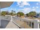 Balcony overlooking quiet street lined with palm trees and charming homes in neighborhood at 4552 River Rd., Little River, SC 29566