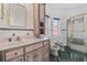 Bright bathroom with vanity, toilet, bidet, and glass-enclosed shower stall at 4552 River Rd., Little River, SC 29566
