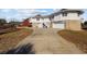 View of a home featuring a long driveway, two-car garage, and stairs to a side entrance at 4552 River Rd., Little River, SC 29566
