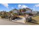 Unique round home with a brick and white exterior, palm trees, and a welcoming driveway at 4552 River Rd., Little River, SC 29566