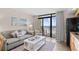 Comfortable living room area with a sofa and view of the ocean from the balcony at 4800 S Ocean Blvd. # 514, North Myrtle Beach, SC 29582