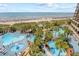 An aerial view of a complex with multiple pools, palm trees, and a sandy beach at 4800 S Ocean Blvd. # 514, North Myrtle Beach, SC 29582