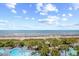 An aerial shot of a pool with ocean views surrounded by palm trees and a sandy beach at 4800 S Ocean Blvd. # 514, North Myrtle Beach, SC 29582