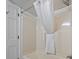 Clean bathroom featuring a shower and tub with white shower curtain and nearby door at 4800 S Ocean Blvd. # 920, North Myrtle Beach, SC 29582