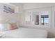 Bedroom featuring a bed, shuttered windows, neutral tones, wood-look flooring, and bright lighting at 4800 S Ocean Blvd. # 920, North Myrtle Beach, SC 29582