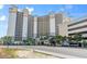 Hotel exterior with multiple levels, balconies, signage, and lush greenery in a well-maintained landscape at 4800 S Ocean Blvd. # 920, North Myrtle Beach, SC 29582