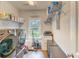 Bright laundry room with washer, dryer, shelving, and large window at 4867 Wolf Trail, Conway, SC 29527