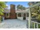 Backyard view featuring a deck, a brick chimney, a screened-in porch, and greenery at 4920 Meadow St., Loris, SC 29569