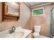 Cozy bathroom featuring a classic sink, mirror, toilet, and window allowing natural light at 4920 Meadow St., Loris, SC 29569