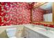 Bathroom with decorative wallpaper featuring double sinks, a large mirror and a toilet at 4920 Meadow St., Loris, SC 29569