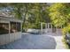 Wooden deck with a screened-in porch, a bench, a gazebo, and lush trees in the background at 4920 Meadow St., Loris, SC 29569