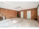 Spacious garage featuring two white doors, wood-paneled walls, and concrete floors at 4920 Meadow St., Loris, SC 29569