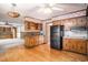 Open kitchen with light-colored cabinets, black appliances, tile backsplash, and wood flooring at 4920 Meadow St., Loris, SC 29569