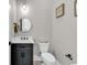 Stylish powder room featuring modern fixtures, a round mirror, and a dark cabinet at 558 Oxbow Dr., Myrtle Beach, SC 29579
