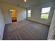 Sunlit bedroom with plush carpeting, two large windows, and a view into the ensuite bathroom at 594 Castillo Dr., Loris, SC 29569