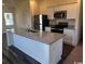 Granite island with stainless sink and faucet, stainless appliances, and white cabinets in an open-concept kitchen at 594 Castillo Dr., Loris, SC 29569