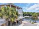 Unique raised house with a serene waterfront view, featuring ample deck space and lush palm trees at 6001 - Mh 17A South Kings Hwy., Myrtle Beach, SC 29575