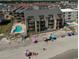 Aerial view of condo building on the beach with an outdoor swimming pool, balconies, and beach access at 618 N Waccamaw Dr. # B7, Garden City Beach, SC 29576