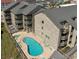 Aerial view of condo building on the beach with an outdoor swimming pool, balconies, and beach access at 618 N Waccamaw Dr. # B7, Garden City Beach, SC 29576