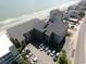 Aerial view of an oceanfront condo building with parking and beach access at 618 N Waccamaw Dr. # B7, Garden City Beach, SC 29576