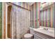Full bathroom with colorful wallpaper, a shower/tub combo, and a white vanity at 618 N Waccamaw Dr. # B7, Garden City Beach, SC 29576