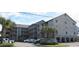 Attractive condo complex with a large parking area and palm trees offering a beach lifestyle at 618 N Waccamaw Dr. # B7, Garden City Beach, SC 29576