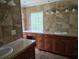 Luxurious bathroom features tile countertops, wood cabinets and a window letting in natural light at 6542 Wellington Dr., Murrells Inlet, SC 29576