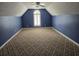 This bedroom features neutral carpet, large window with shuttered blinds, dark blue walls and a ceiling fan at 6542 Wellington Dr., Murrells Inlet, SC 29576