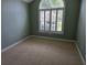 This bedroom features a neutral carpet, a large window with shuttered blinds, and light green colored walls at 6542 Wellington Dr., Murrells Inlet, SC 29576