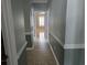 Inviting hallway with neutral tile flooring and elegant wainscoting, leading to sunlit room at 6542 Wellington Dr., Murrells Inlet, SC 29576