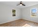 Bright bedroom features wood-look floors, ceiling fan, and natural light from two windows at 704 Bonnie Dr., Myrtle Beach, SC 29588