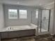 Elegant bathroom featuring a soaking tub and a separate glass-enclosed shower with marble-style tiling at 71 Mohican Dr., Georgetown, SC 29440