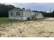 Well-maintained gray mobile home with a small porch and spacious yard surrounded by trees at 71 Mohican Dr., Georgetown, SC 29440