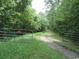 A rustic driveway entrance with gate surrounded by dense trees and greenery at 742 Se Hebron Dr., Conway, SC 29527