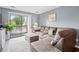 Well-lit living room with a comfortable couch, balcony access, and view of the pool at 7700 Porcher Dr. # 3205, Myrtle Beach, SC 29572