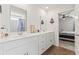 Well-lit bathroom with double sinks, white cabinets, and a view into the bedroom at 798 Woodland Farms Circle, Aynor, SC 29511