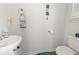 Well-lit bathroom featuring a pedestal sink, toilet, and coastal-themed decorations on a clean, neutral color palette at 798 Woodland Farms Circle, Aynor, SC 29511