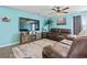 Cozy living room with a large TV, leather seating, wood-look floors, and contemporary decor at 798 Woodland Farms Circle, Aynor, SC 29511