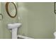 Stylish half-bathroom featuring a pedestal sink, framed mirror, and green walls at 945 Rosencrans Ln. # B, Myrtle Beach, SC 29577
