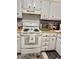 Kitchen with white cabinets, a range with tiled backsplash, and charming coastal-themed decor at 9501 Shore Dr. # 323, Myrtle Beach, SC 29572