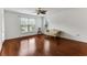 A spacious, sunlit bedroom with hardwood floors has a ceiling fan and a comfortable floral sofa at 964 Great Egret Circle Sw # B, Sunset Beach, NC 28468
