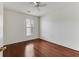 A bright bedroom features hardwood floors, a ceiling fan, and a window with blinds, creating a cozy atmosphere at 964 Great Egret Circle Sw # B, Sunset Beach, NC 28468